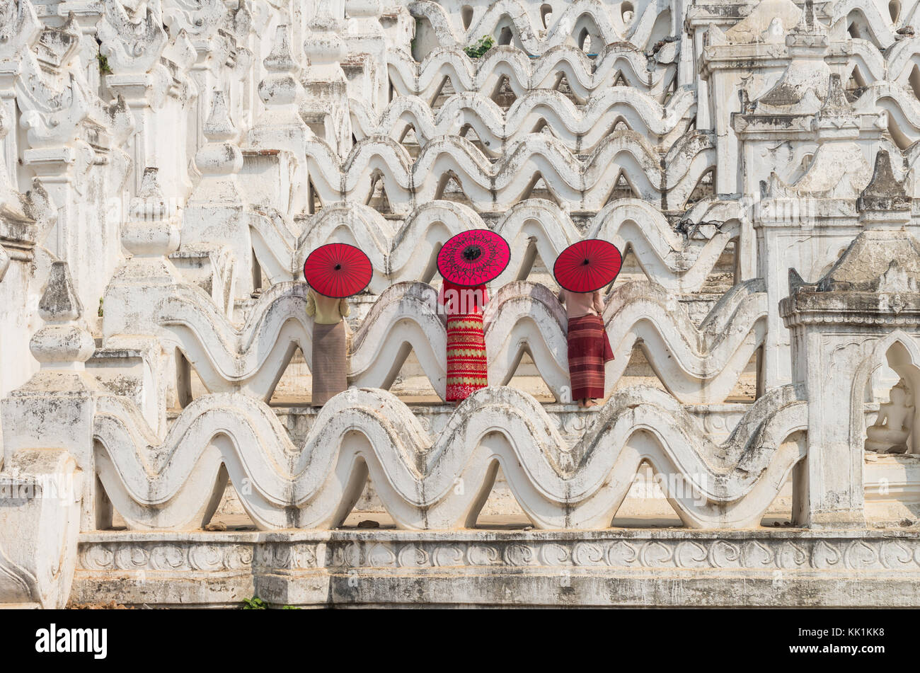 Rückseite der drei buddhistischen Birmanen mit traditionellen Regenschirm auf dem mya Thein tan Pagode in Bagan, Mandalay, Myanmar Stockfoto