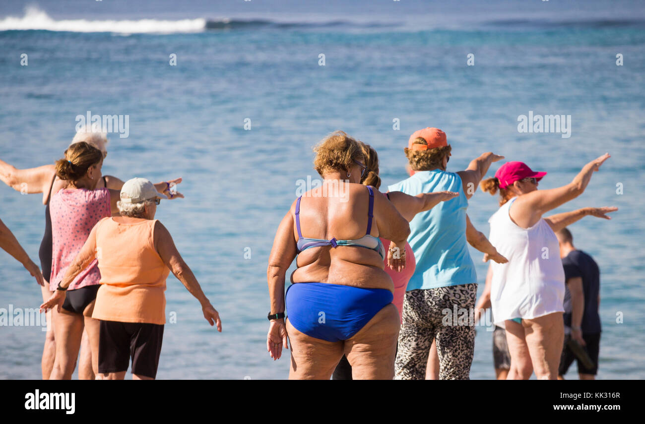 Ältere Frauen aus der Region durchlaufen ihre Routine bei ihrer täglichen Keep-Fit-Klasse am Strand in Spanien. Stockfoto