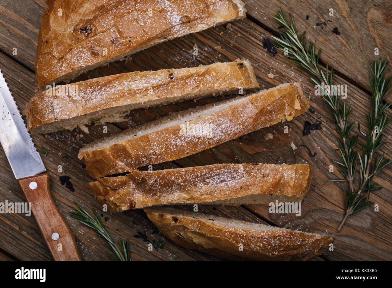 Ein frisch zubereitetes Brot in Scheiben schneiden, mit Rosmarin Nahaufnahme, Ansicht von oben Stockfoto