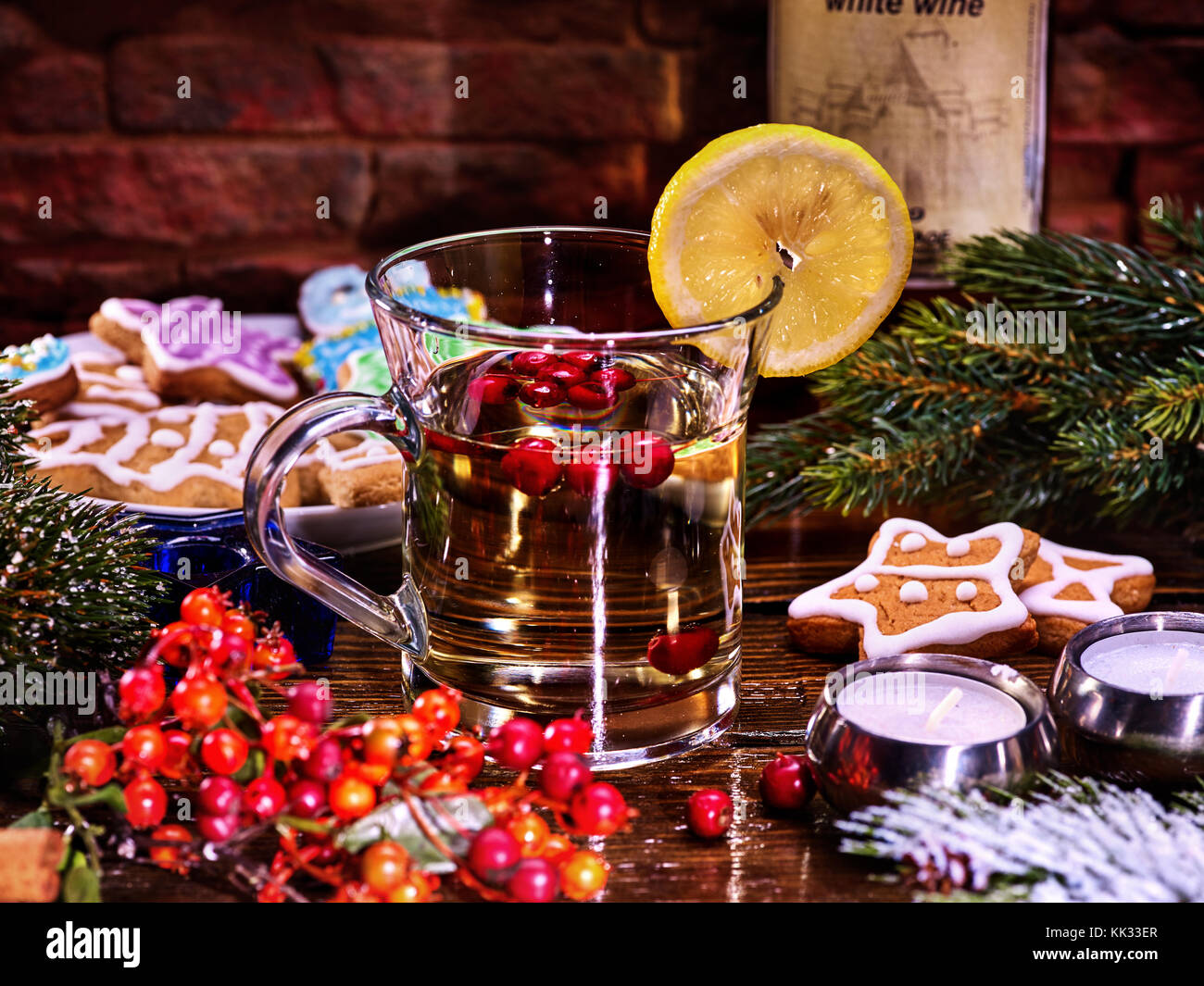 Weihnachten Tee Tasse Glas und bunten Cookies auf Form Sterne auf Platte mit Tannenzweigen. mug Dekoration Zitronenscheibe auf Holztisch. Xmas behandelt und Stockfoto