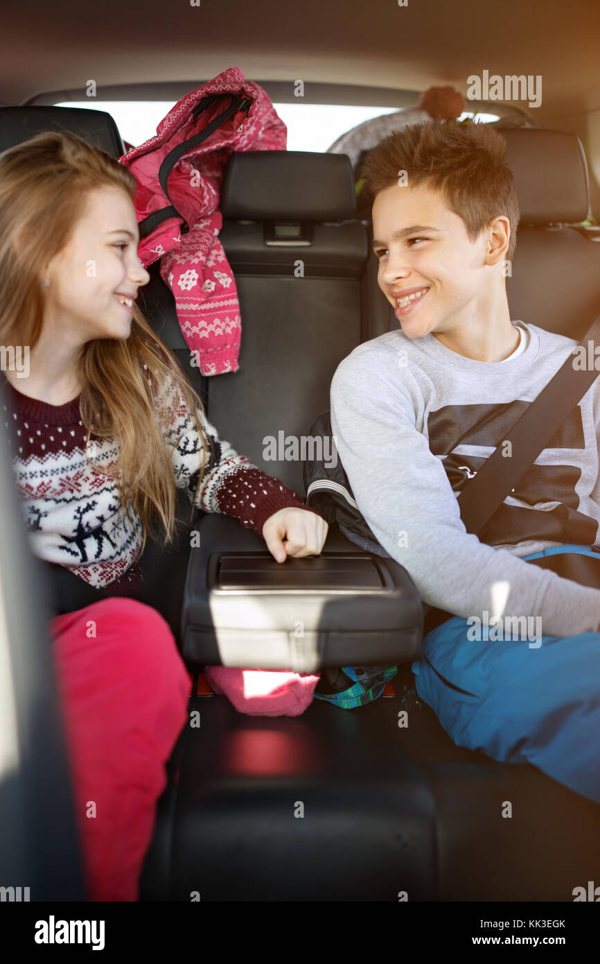 Lächelnde Junge und Mädchen auf Auto fährt auf Skiurlaub Stockfoto