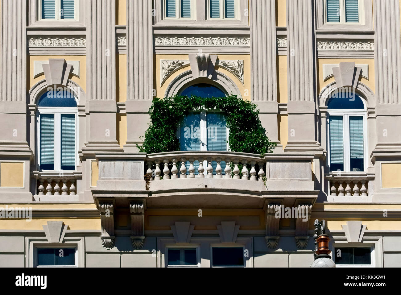 Trieste Gebäude außen, Fassade und Balustrade Balkon mit Kletterpflanzen, in Piazza della Borsa.Trieste, Friaul Julisch Venetien, Italien. Nahaufnahme. Stockfoto