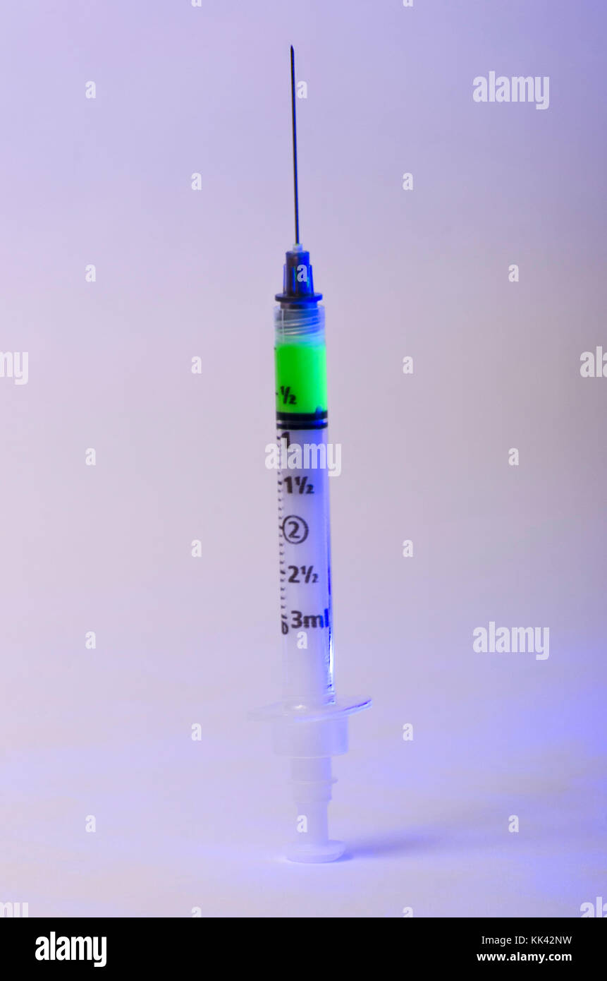 Injektionsspritzen mit leuchtenden grünen Stoff begründe radioaktive Stoffe oder giftige Substanz betriebsbereit geladen Stockfoto