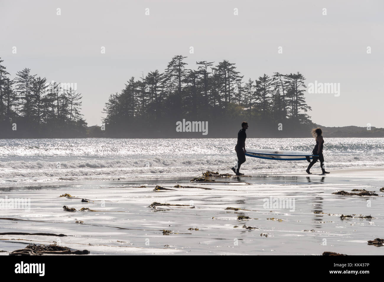 Chesterman Strand in der Nähe von Tofino, BC, Kanada (September 2017) - zwei Personen mit einem Surfind Board Stockfoto
