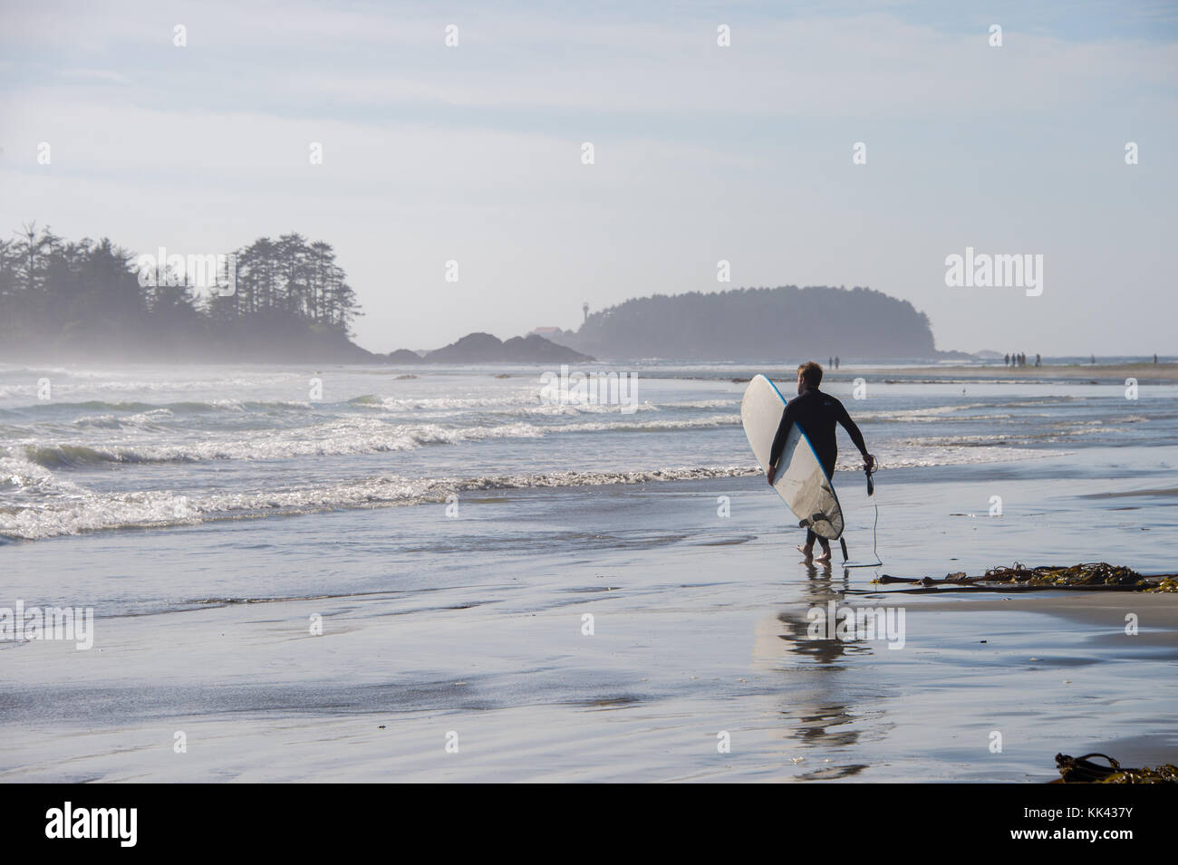 Chesterman Strand in der Nähe von Tofino, BC, Kanada (September 2017) - Mann mit Surfbrett. Stockfoto