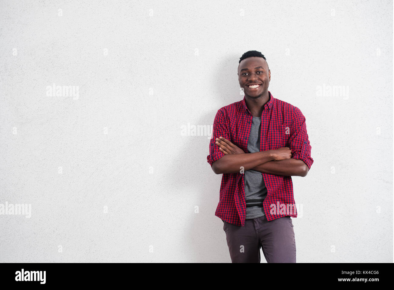 Menschen und Lifestyle Konzept. Portrait von Fröhlicher und positiver Junge afrikanische Männer in guter Stimmung, das Tragen der roten Hemd lächelt Fröhlich seine perfekte Stockfoto