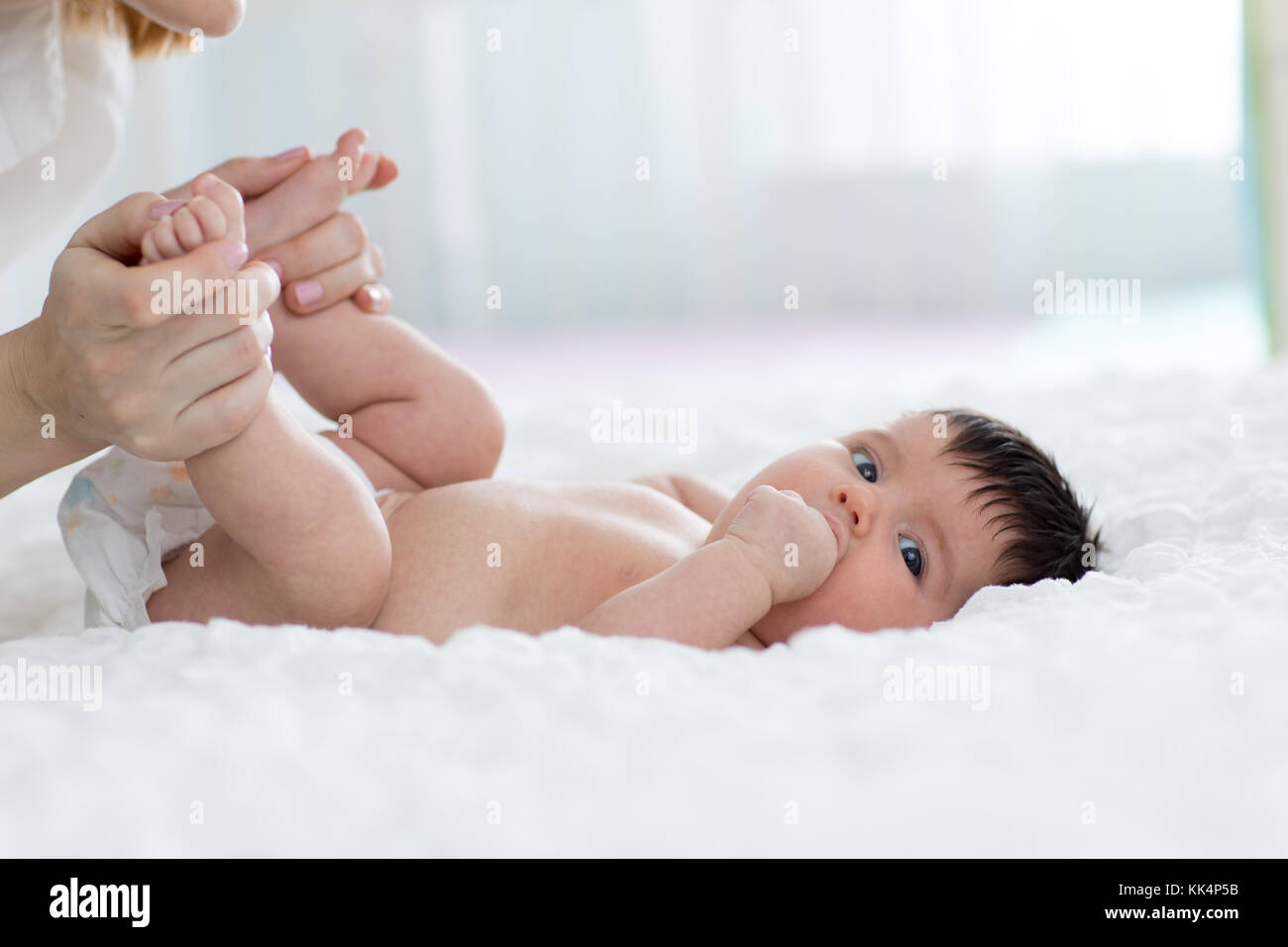 Baby genießt Massage von der Mutter Stockfoto