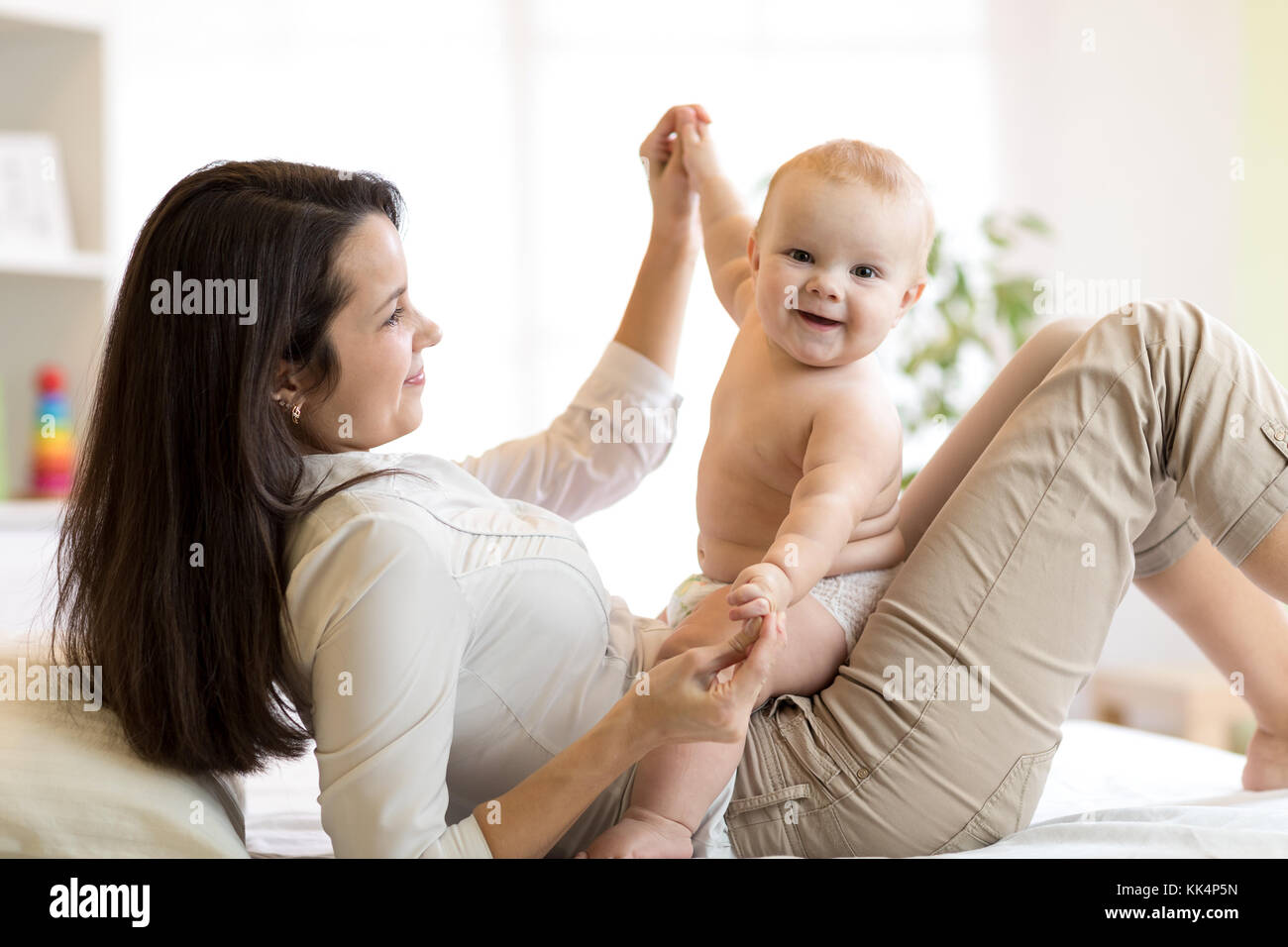 Mama und Baby boy in Windel spielen in sonnige Zimmer. Mutter und Kind zu Hause entspannen. Familie gemeinsam Spaß zu haben. Stockfoto