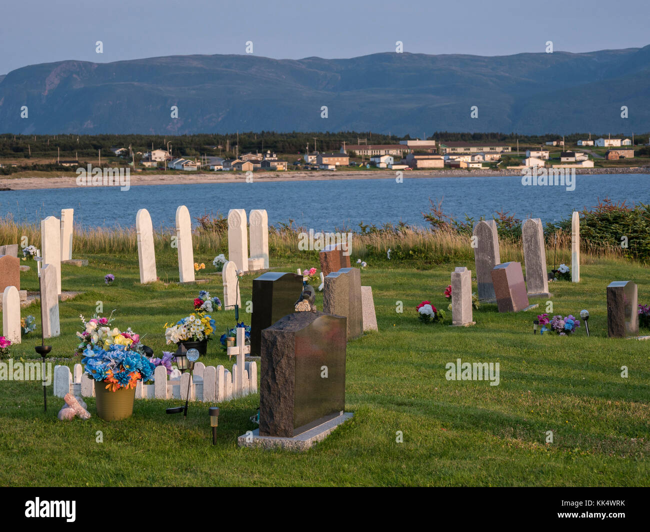 Anglikanische Friedhof mit der Stadt im Hintergrund, Kuhkopf Dorf, Gros Morne National Park, Neufundland, Kanada. Stockfoto