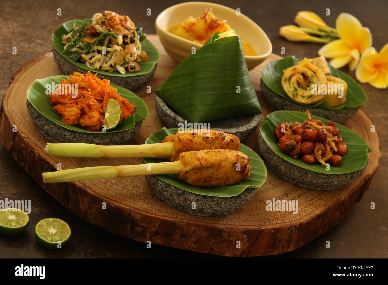 Balinesische Essen Sampler. Verschiedene balinesische Gerichte in kleinen Portionen auf mini Stein Mörser dann auf Holzbrett angeordnet. Stockfoto