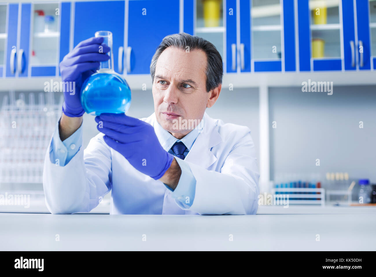 Schwere smart Mann hält ein Kolben Stockfoto