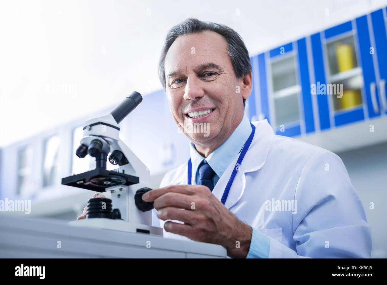 Freuen smart Forschungen sitzen vor dem Mikroskop Stockfoto