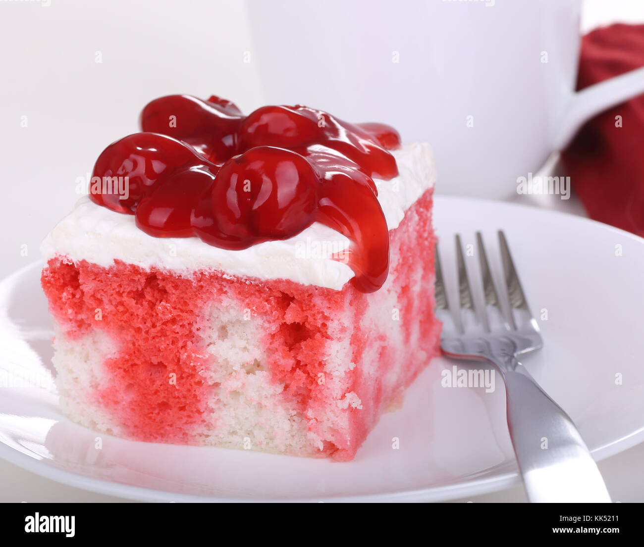 Stück Kuchen mit Sahne auffüllen und Kirschen auf einer Platte Stockfoto