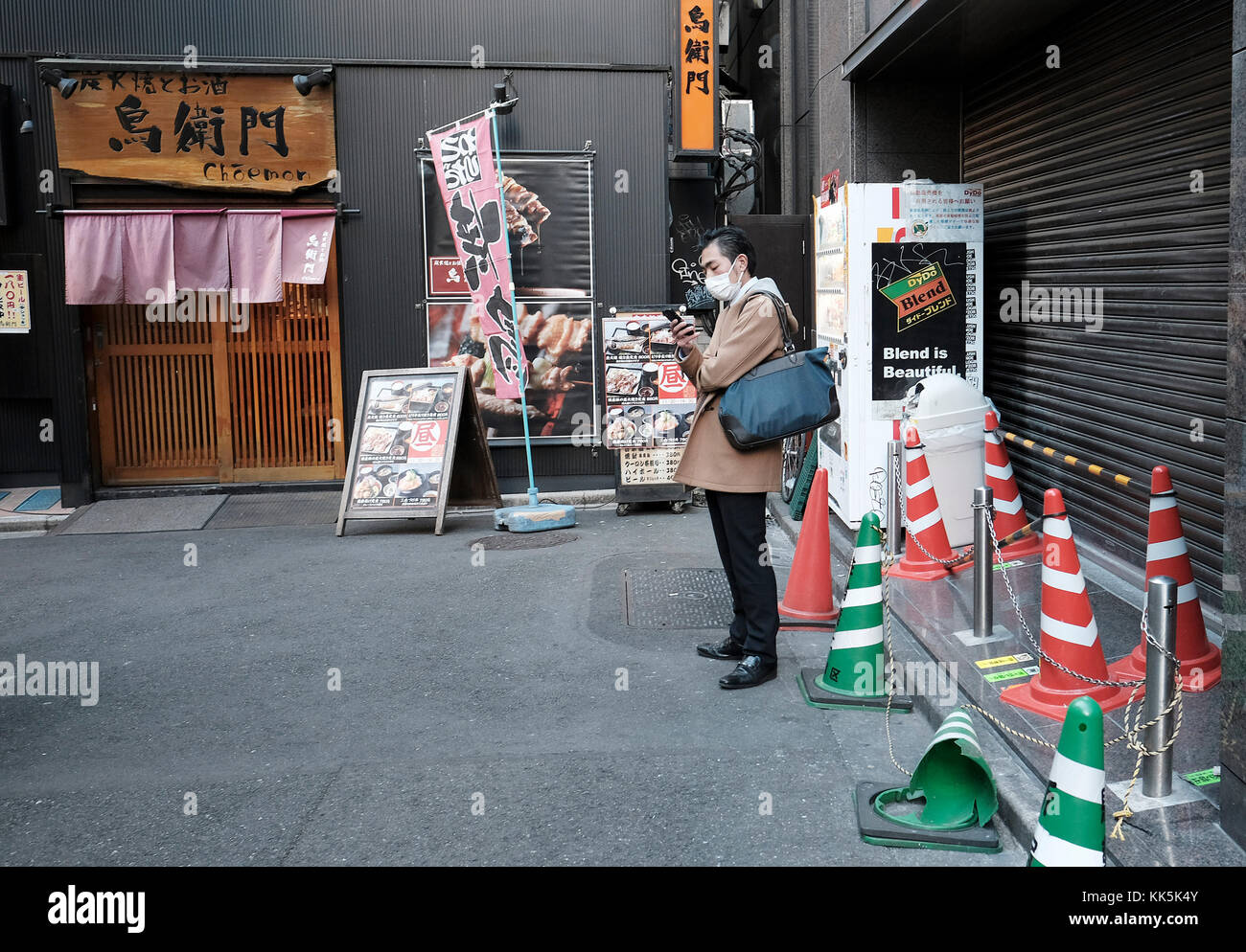 Mann sein Handy bei Backstreet in Tokio prüfen. Stockfoto