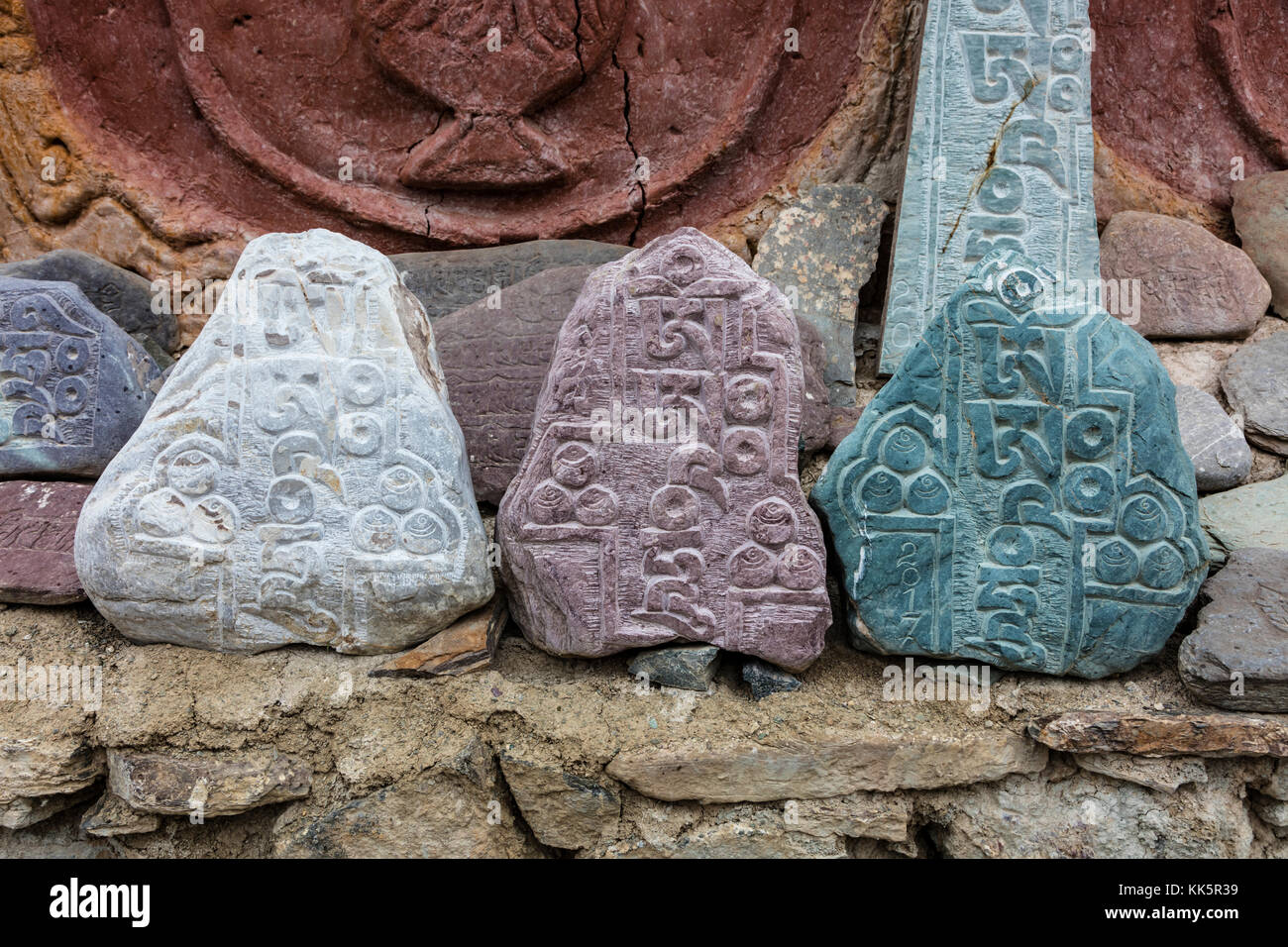 Buddhistische Mani Steine geschnitzt mit Gebete umgeben einen Stupa in LAMAYURU KLOSTER von NAROPA - LADAKH, Indien gegründet. Stockfoto