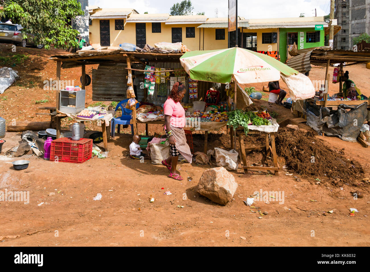 Eine Frau steht, die von ihrem Stall verkaufen Lebensmittel auf der Straße in einer kleinen Stadt, Kenia, Ostafrika Stockfoto