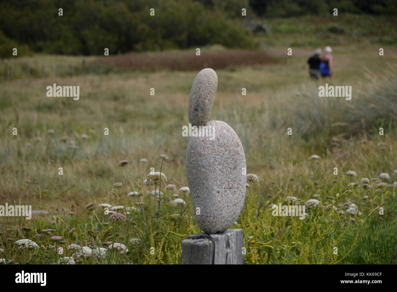 Kleiner Stein ausgeglichen auf großen Stein auf einem alten Fencepost auf der Insel Bryher, Isles of Scilly, Cornwall, Großbritannien. Stockfoto