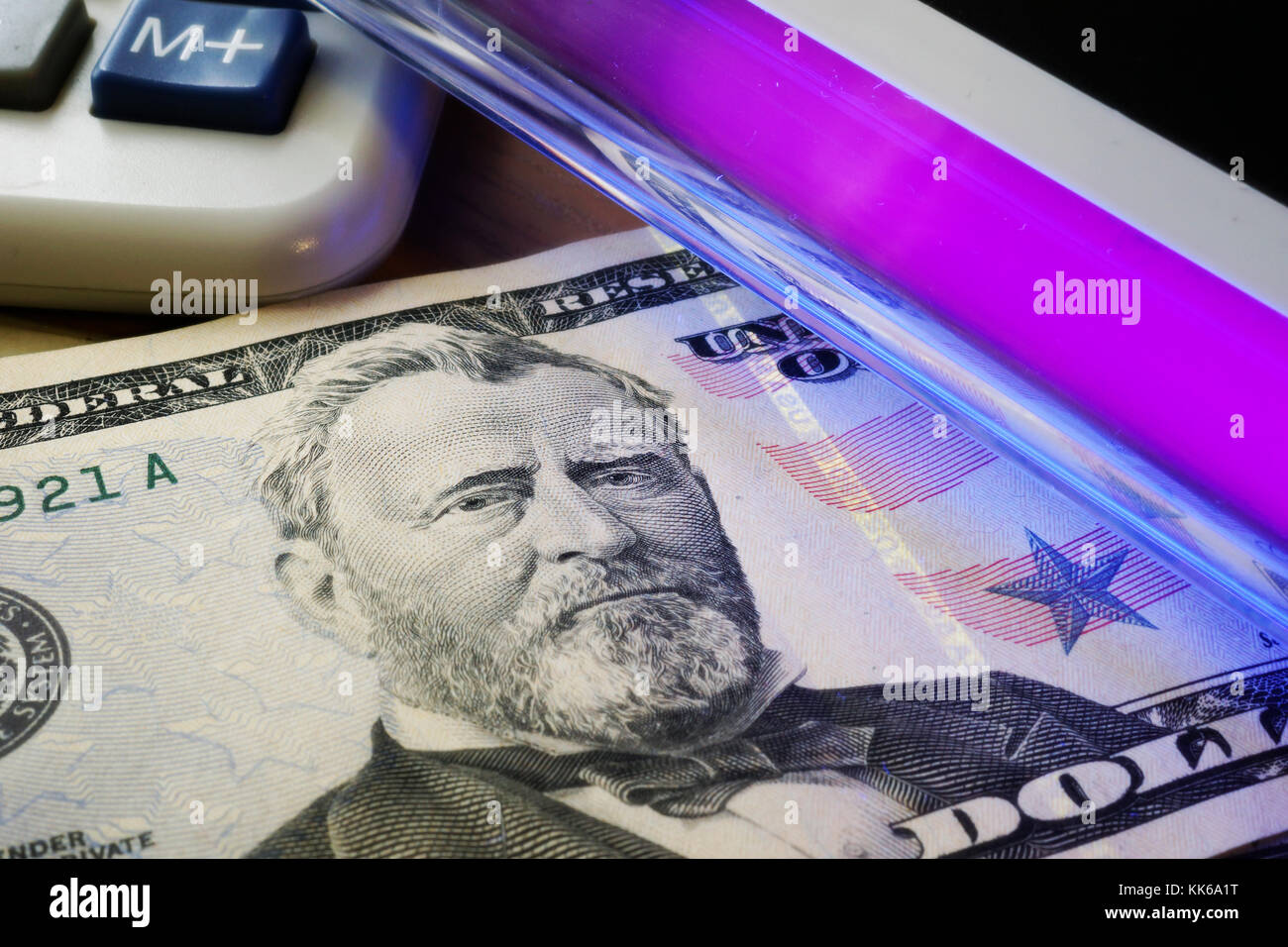 Kontrolle Dollar Banknoten in einem UV-Licht. Falschgeld Konzept. Stockfoto
