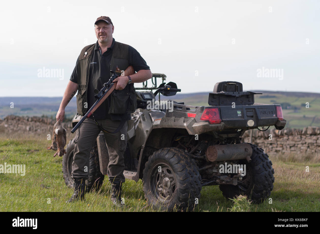 Ein Mann heraus tun Kaninchen Control auf einem Bauernhof in gewohnt, County Durham mit einem .22 Gewehr, und mit einem Quad (ATV) für den Transport. Stockfoto