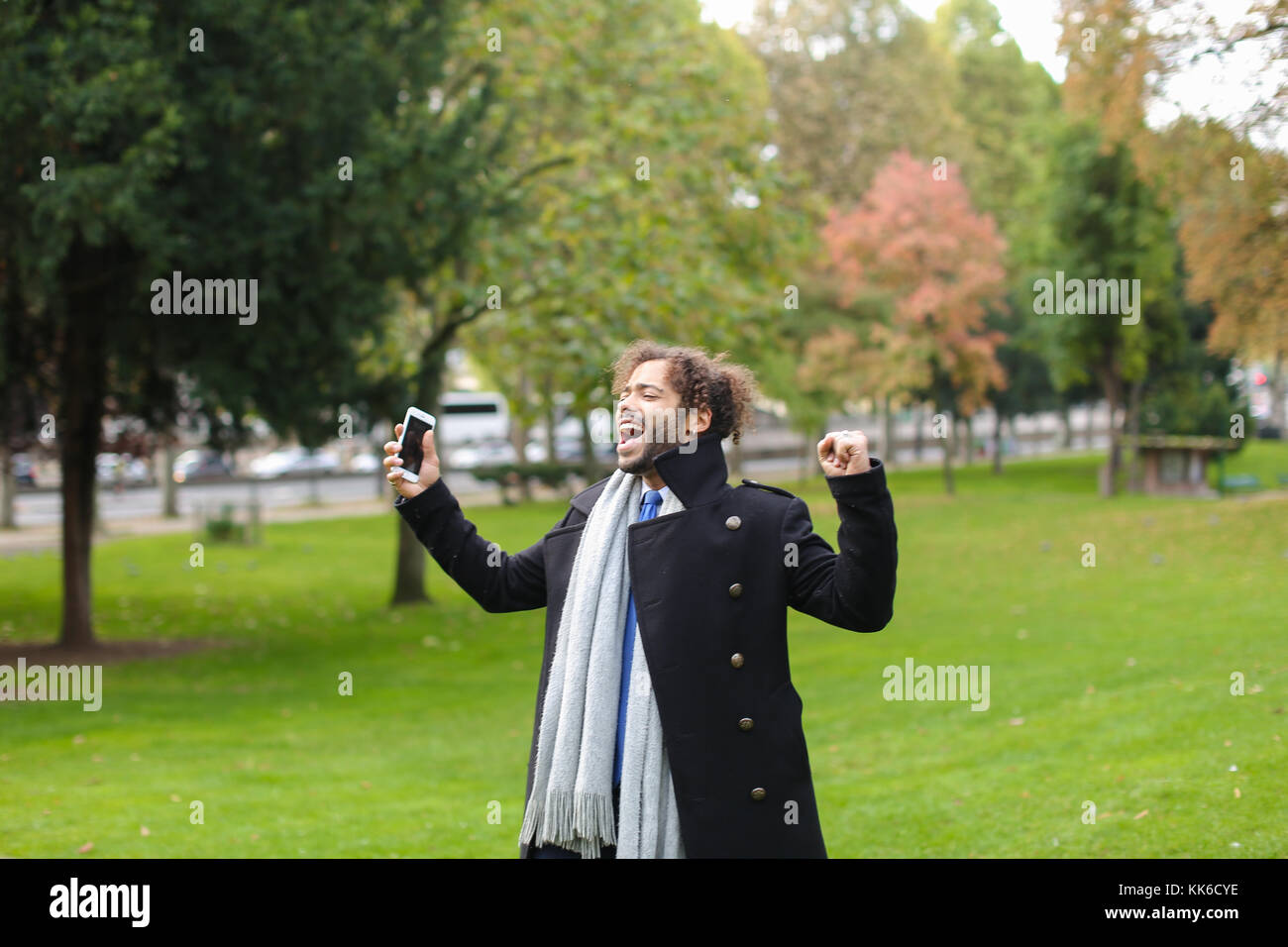 Hispanic Mann chatten mit Freundin auf dem Smartphone im Park. Stockfoto