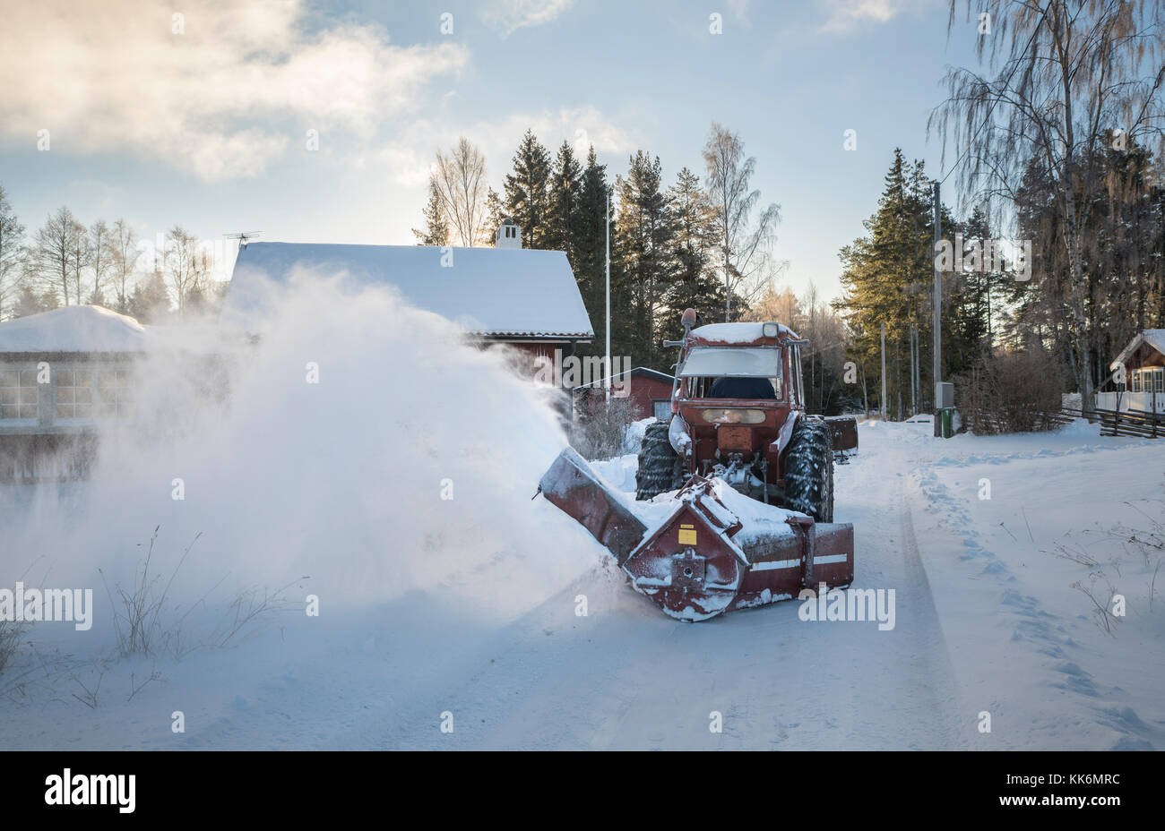 Traktor mit Schnee auf einer Straße in der schwedischen Landschaft, Roslagen, Uppland, Schweden, Skandinavien Pflug. Stockfoto