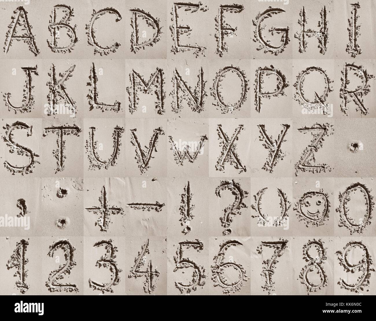 Handschriftliche englischen Alphabet, Zahlen und mathematische Symbole auf dem Sand. Stockfoto