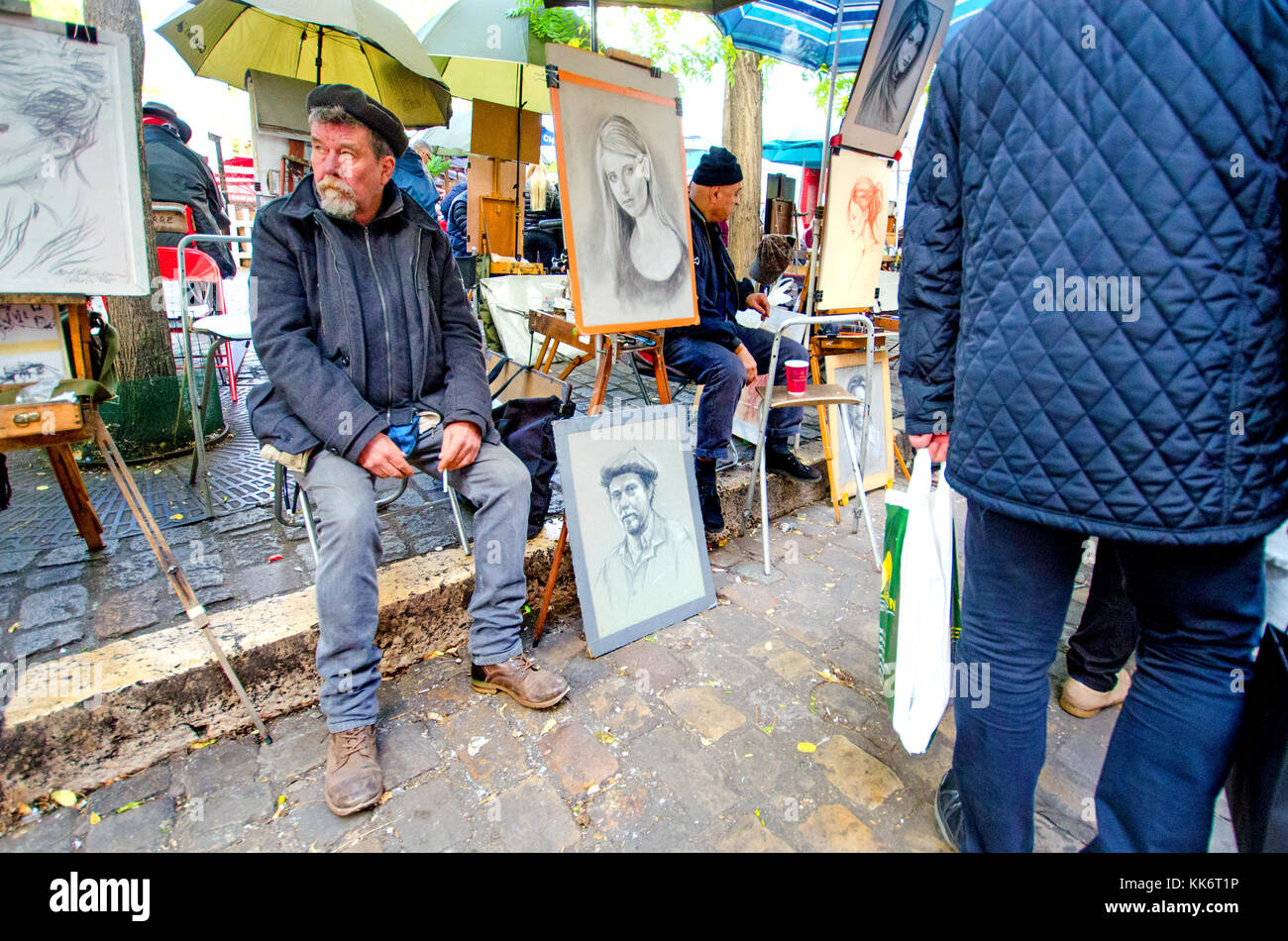 Paris, Frankreich. Montmartre - Place du Tertre - Porträt Künstler mit Selbstportrait, Warten auf Kunden Stockfoto