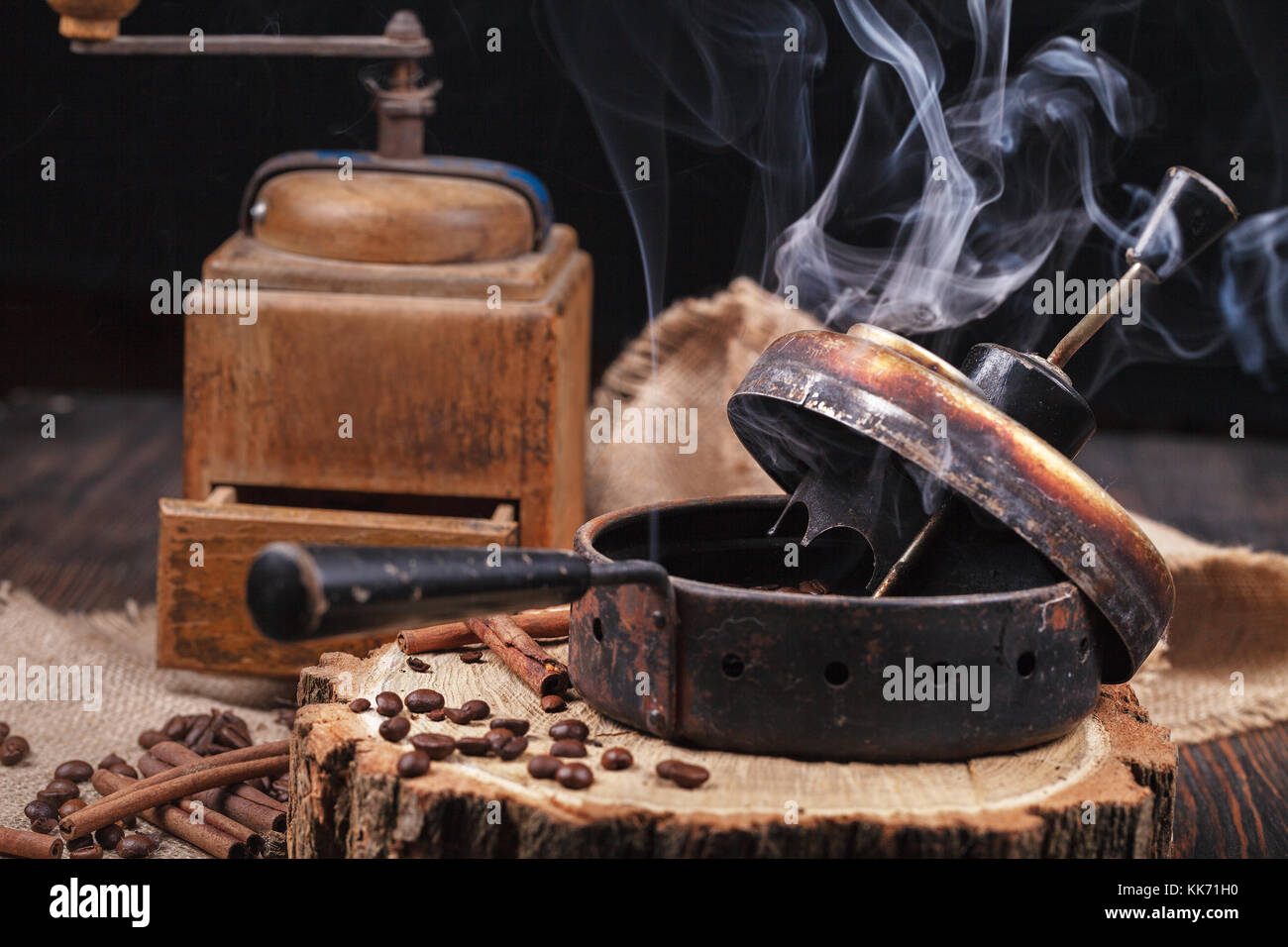 Das Gerät zum Rösten von Kaffee Bohnen, eine alte Handschleifer. smoky Roast Kaffee auf einem Holzständer. studio Beleuchtung. Stockfoto