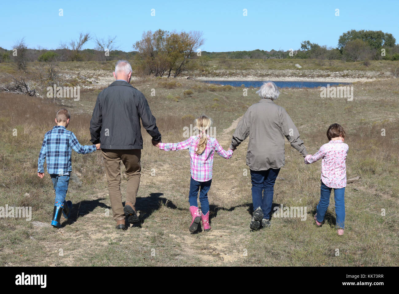 Großeltern spazieren gehen mit ihren Enkelkindern Stockfoto