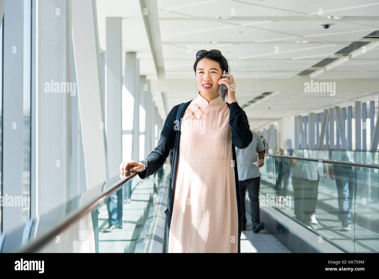 Mädchen mit Telefon, während auf der Fahrsteig innen Stockfoto