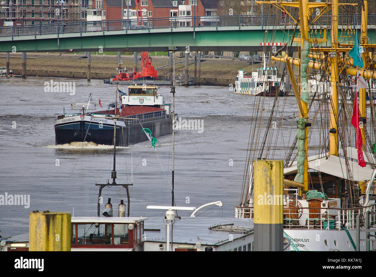 Bremen, Deutschland - 23. November 2017 - Binnenschiff über eine Brücke über die Weser mit Wohngebäuden im Hintergrund und vertäut Stockfoto