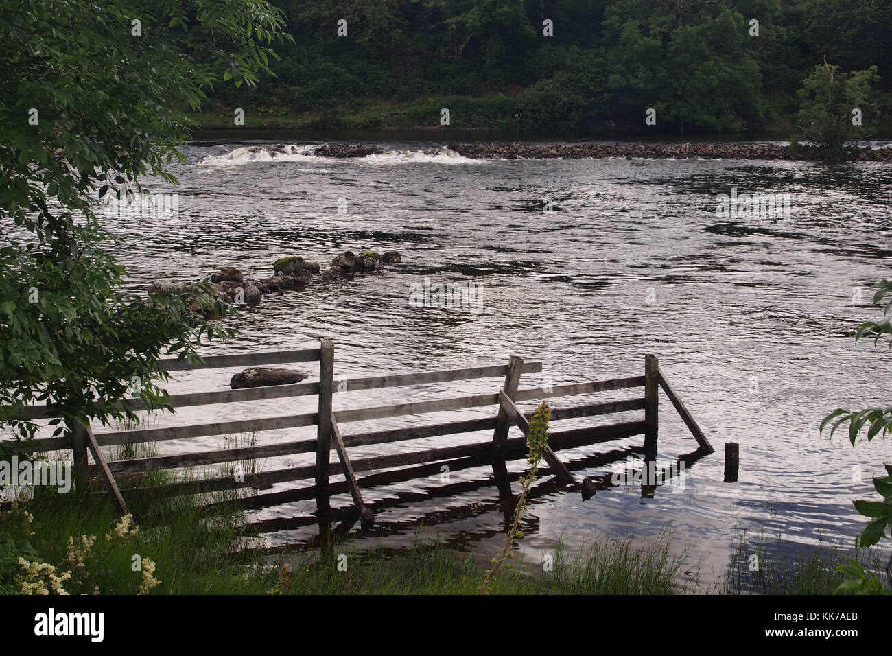 Blick über den Fluss Ewe mit einem Zaun in der Nähe von Poolewe, Schottland Stockfoto