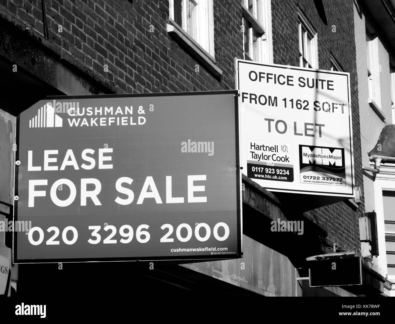 Immobilienmakler Werbeschilder, Einzelhandel Einheit Lease für Verkauf über leerstehenden Ladenlokalen und Büros zu lassen. Stockfoto