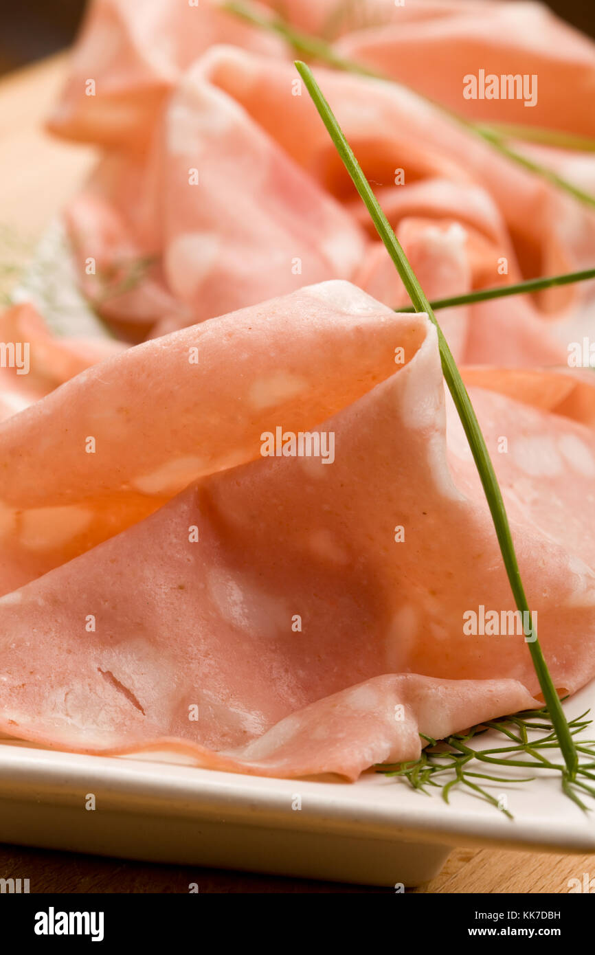 auch genannt Foto dünne Scheiben von italienischen Mortadella Bologna auf kleinen rechteckigen Platte als Vorspeise serviert Stockfoto