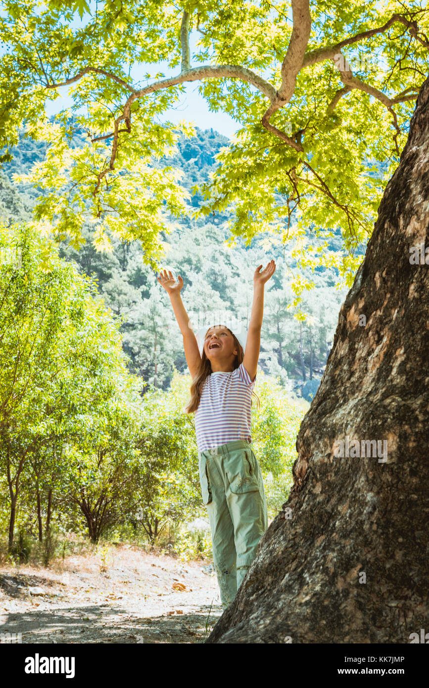 Kleines Mädchen umarmt Big Tree Stockfoto