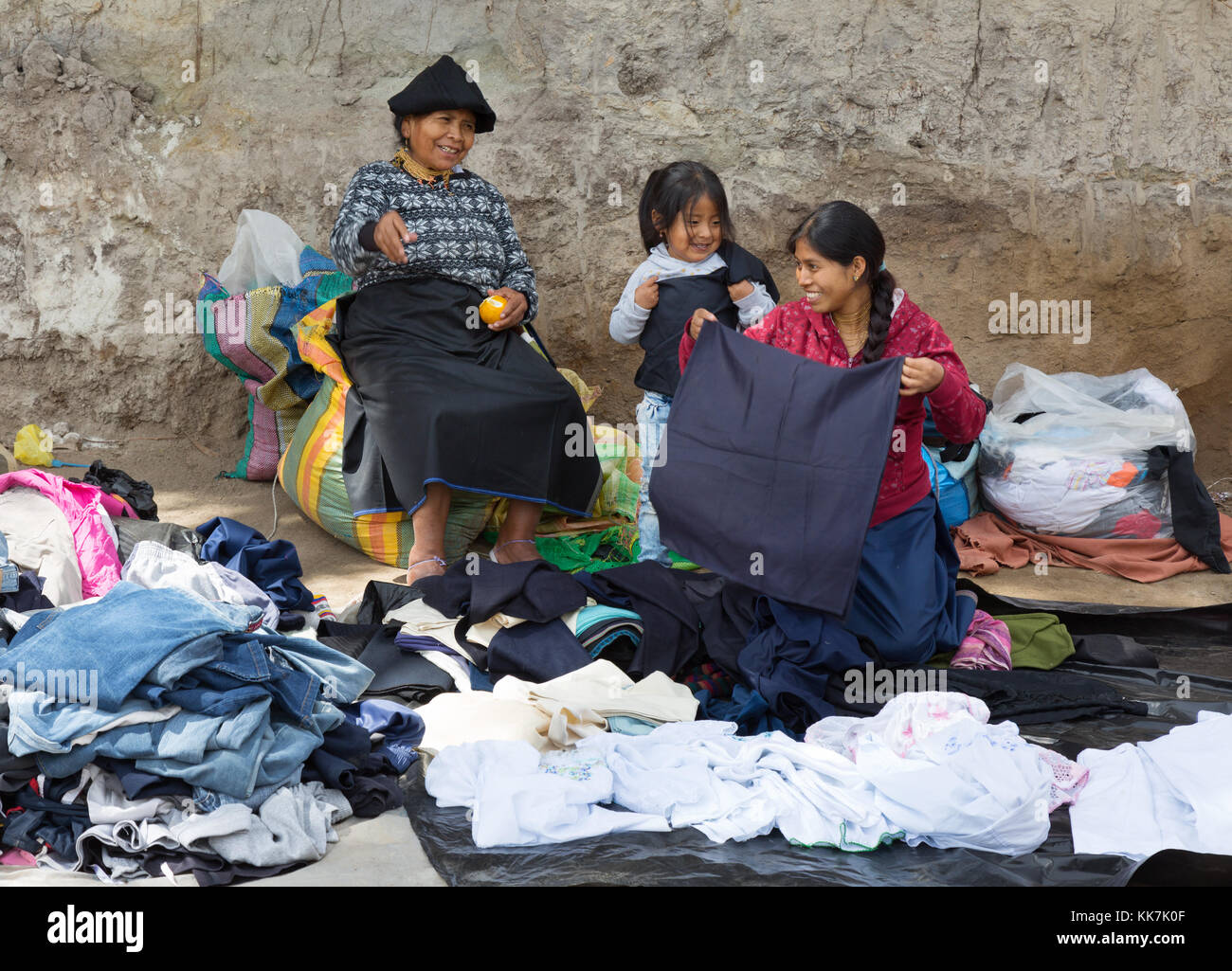 Drei Generationen von Frauen aus derselben Familie, die Kleidung an einem Stand, Otavalo-Markt, Otavalo, Ecuador, Südamerika, verkaufen Stockfoto