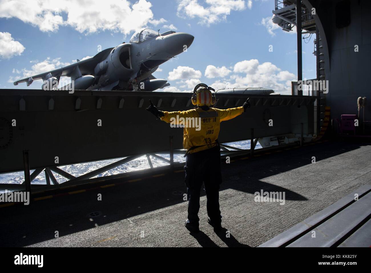 Der Luftfahrt Bootsmann Mate Handhabung 2. Klasse Araminta Mack leitet einen Fahrstuhl Betreiber im Hangar Bucht des Amphibious Assault ship USS Kearsarge LHD3, Atlantik. Bild mit freundlicher Genehmigung von Massenkommunikation Specialist 2. Klasse Shamira Purifoy/US Navy, 2015. Stockfoto