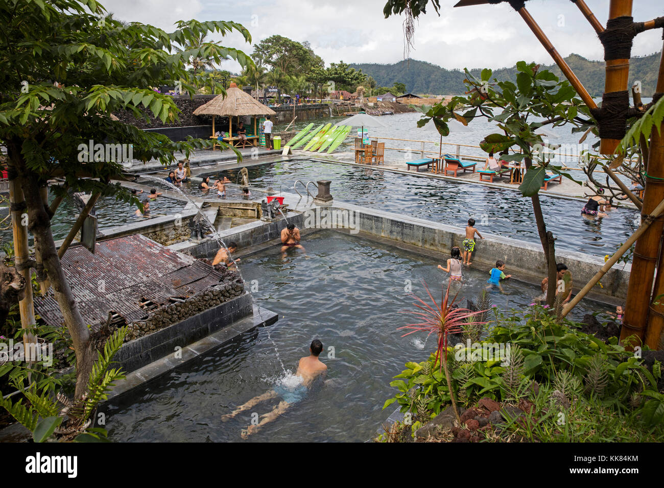 Touristen schwimmen in geothermisch beheizten heißen Quellen in Toya Bungkah / Tirta am Fuße des Mount Batur / Gunung Batur, Bangli Regency, Bali, Indonesien Stockfoto