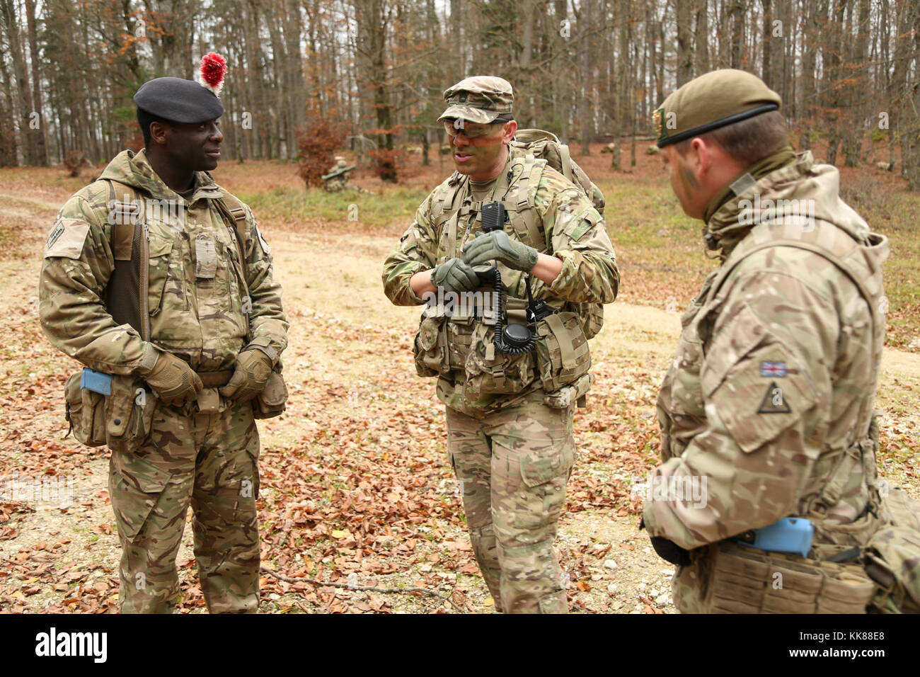 Us-Armee Sgt. 1. Klasse Derek Castro, Mitte, des Joint Multinational Readiness Center (JMRC) (Operations Group) Warhog Beobachter Trainer Trainer Team, erörtert die Mission Taktiken mit Lanze Cpl. Ismael Griffiths und Cpl. Jake Ward Der 1.BATAILLON, Royal Regiment der Füsiliere, während die Durchführung einer Aufklärungsmission während der Übung Allied Geist VII bei der US-Armee JMRC in Hohenfels, Deutschland, Nov. 8, 2017. Etwa 4.050 Mitglieder aus 13 Nationen nehmen an der übung Allied Geist VII 7th Army Training Befehl des Truppenübungsplatzes Hohenfels, Deutschland, Okt.30 bis N Stockfoto