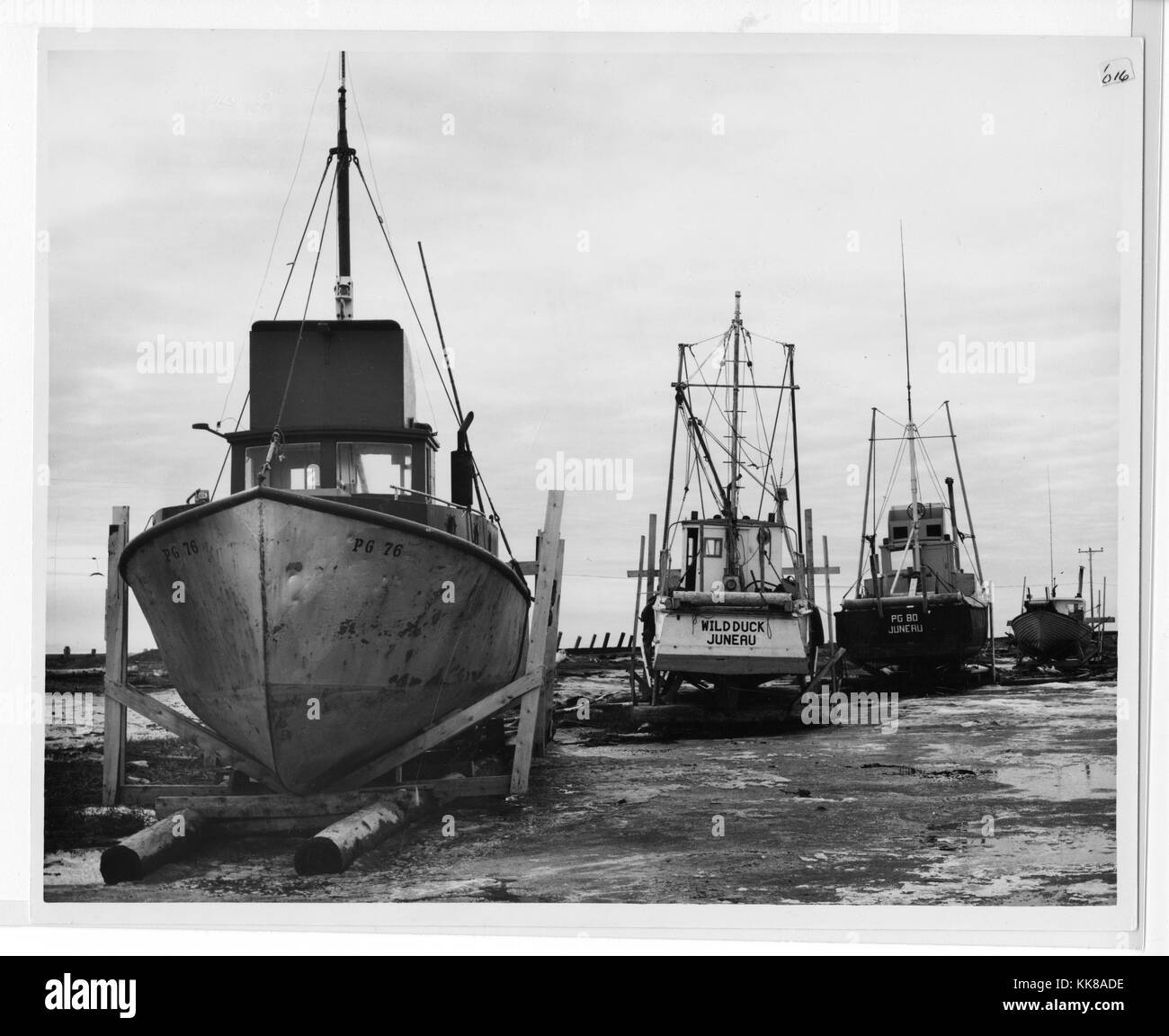 Ein Foto, eine Linie von Booten, trocken wurden angedockt wird im Anschluss an die Alaska Erdbeben 1965, die Boote in einem Bereich, in nassen Schlamm, ist jetzt weit vom Wasser bedeckt Sitzen, das Erdbeben einen Tsunami, der viele Schäden in der Umgebung verursacht, die 92 Erdbeben in Prince William Sound entstanden und ist der zweitgrößte Erdbeben, die jemals verzeichnet wurde, Homer, Alaska, 1964. Stockfoto