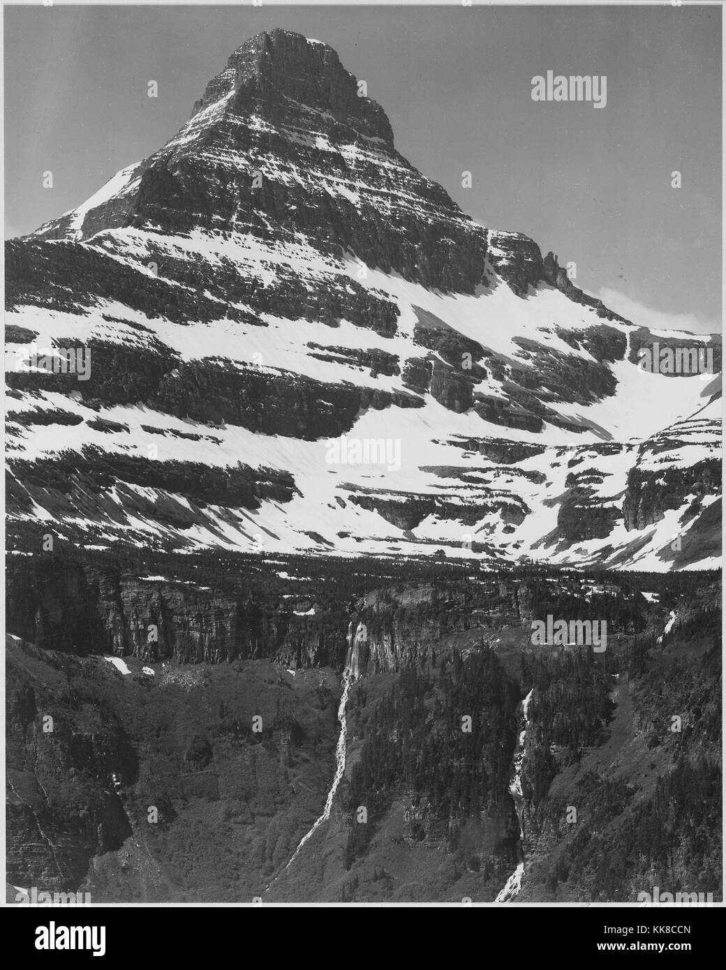 Schwarz-weiß Foto, volle Sicht auf den schneebedeckten Berg, einschließlich Bereich unter Timberline, Untertiteln' im Glacier National Park', von Ansel Adams, von Fotografien von Nationalparks und Monumente, Montana, United States, 1941. Stockfoto