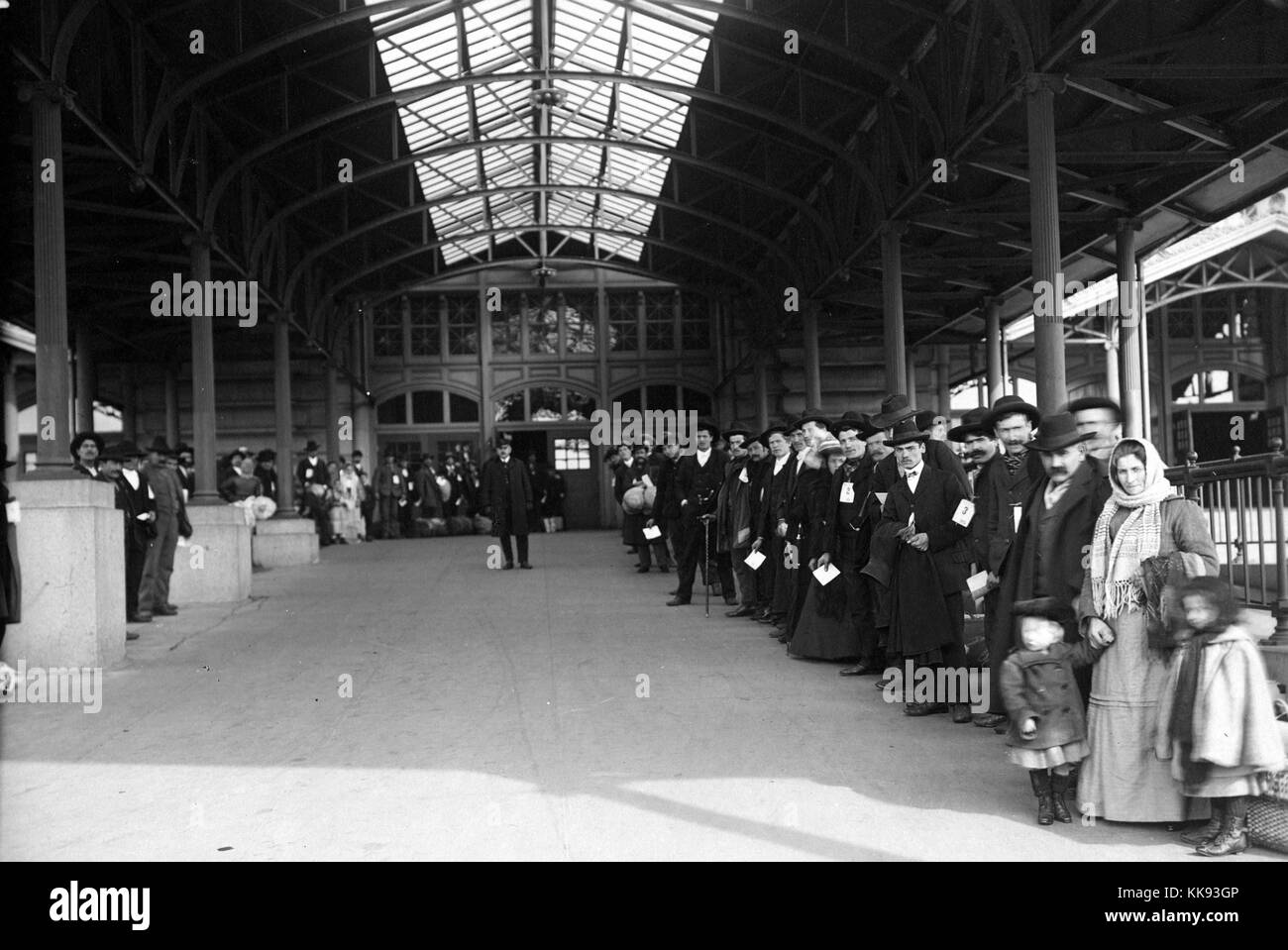 Schwarz-weiß Fotografie eine große Gruppe von Einwanderern, die draußen warten aus Ellis Island, von Edwin Levick, Ellis Island, New York, 1907. Von der New York Public Library. Stockfoto