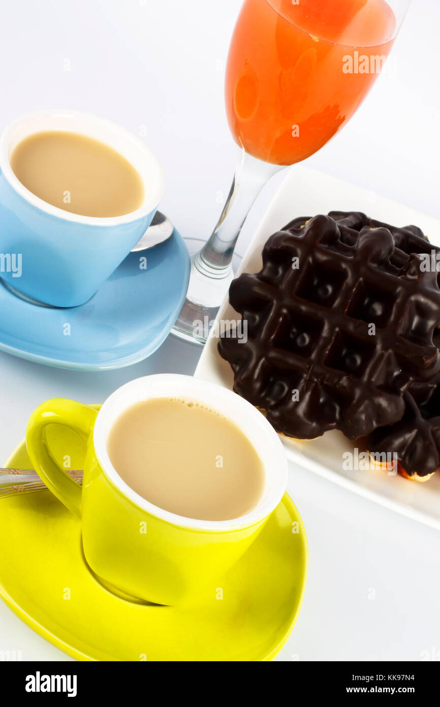 Tassen Tee mit Milch und Rote Grapefruit Saft und Waffeln mit Schokolade. Stockfoto