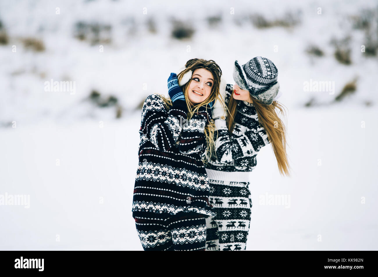 Paar junge Frau. Mädchen trägt warme Mütze Mädchen schließt Ohren's Freund mit ihr die Hände in Handschuhe im kalten Winter Stockfoto