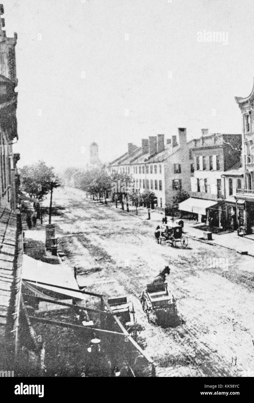 Ein Foto von der Hauptstraße in Lexington, Pferdewagen, auf den breiten, unbefestigten Straße zu sehen sind, die Strasse ist teilweise mit Bäumen, Gebäuden auf beiden Seiten der Straße, die Gebäude sind Vertreter der Bürgerkrieg Architektur, Kentucky, 1940. Von der New York Public Library. Stockfoto