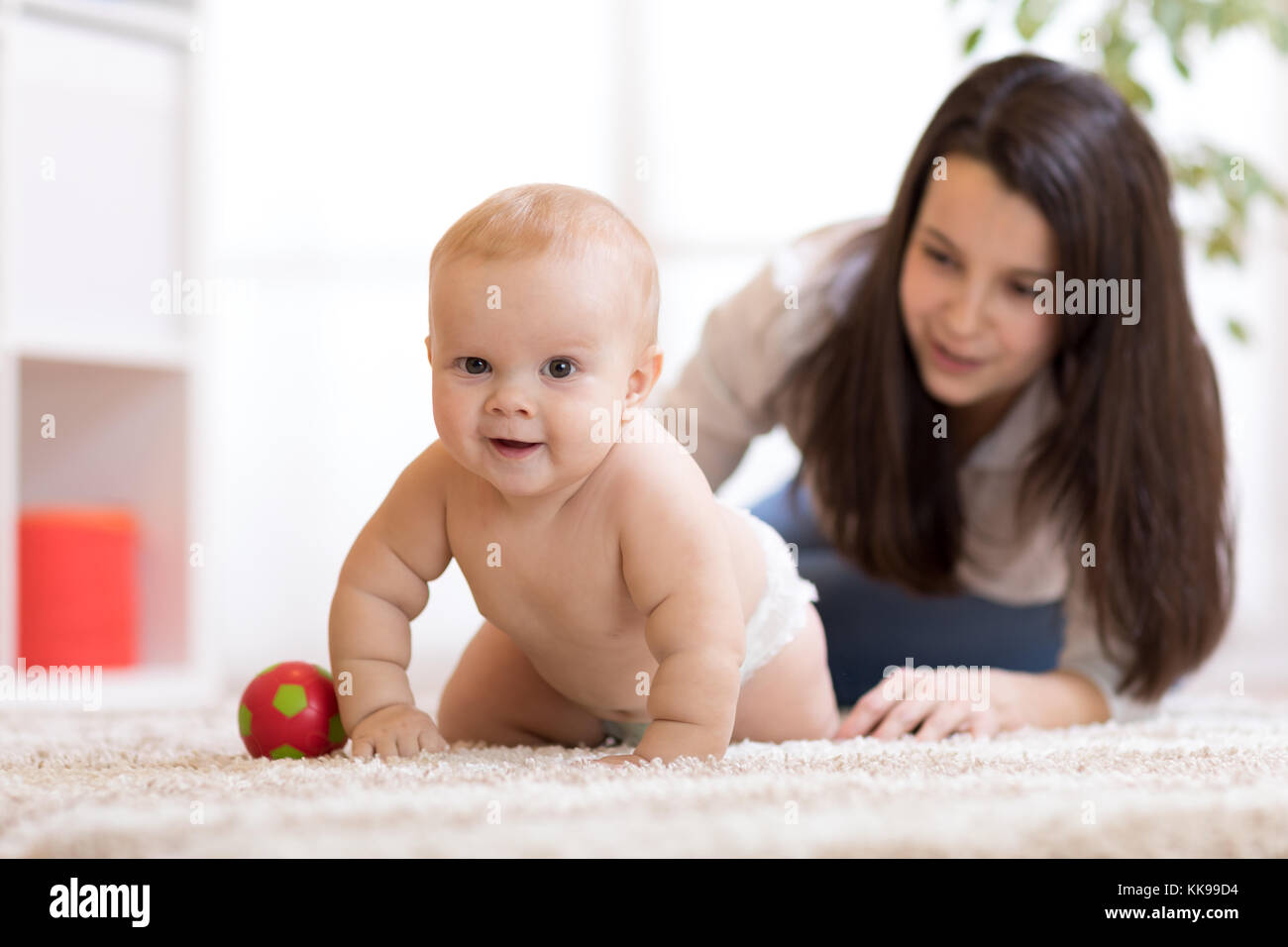 Mutter spielt mit Kriechen auf dem Boden baby Stockfoto