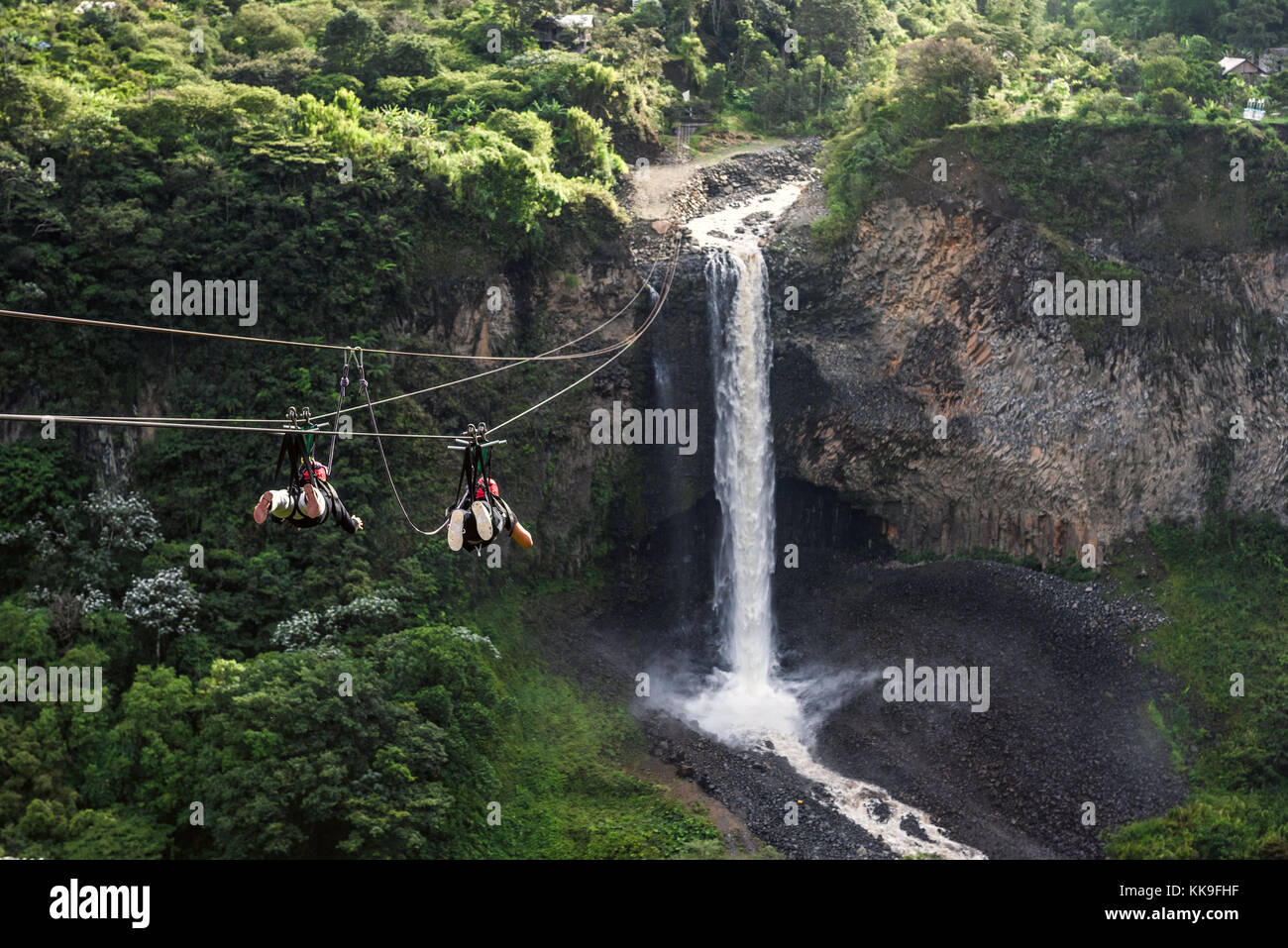 Touristen gleiten auf die Zip Line Reise gegen Bridal Veil (Manto de La Novia), Wasserfall in Kaskaden route, Banos, Ecuador Stockfoto