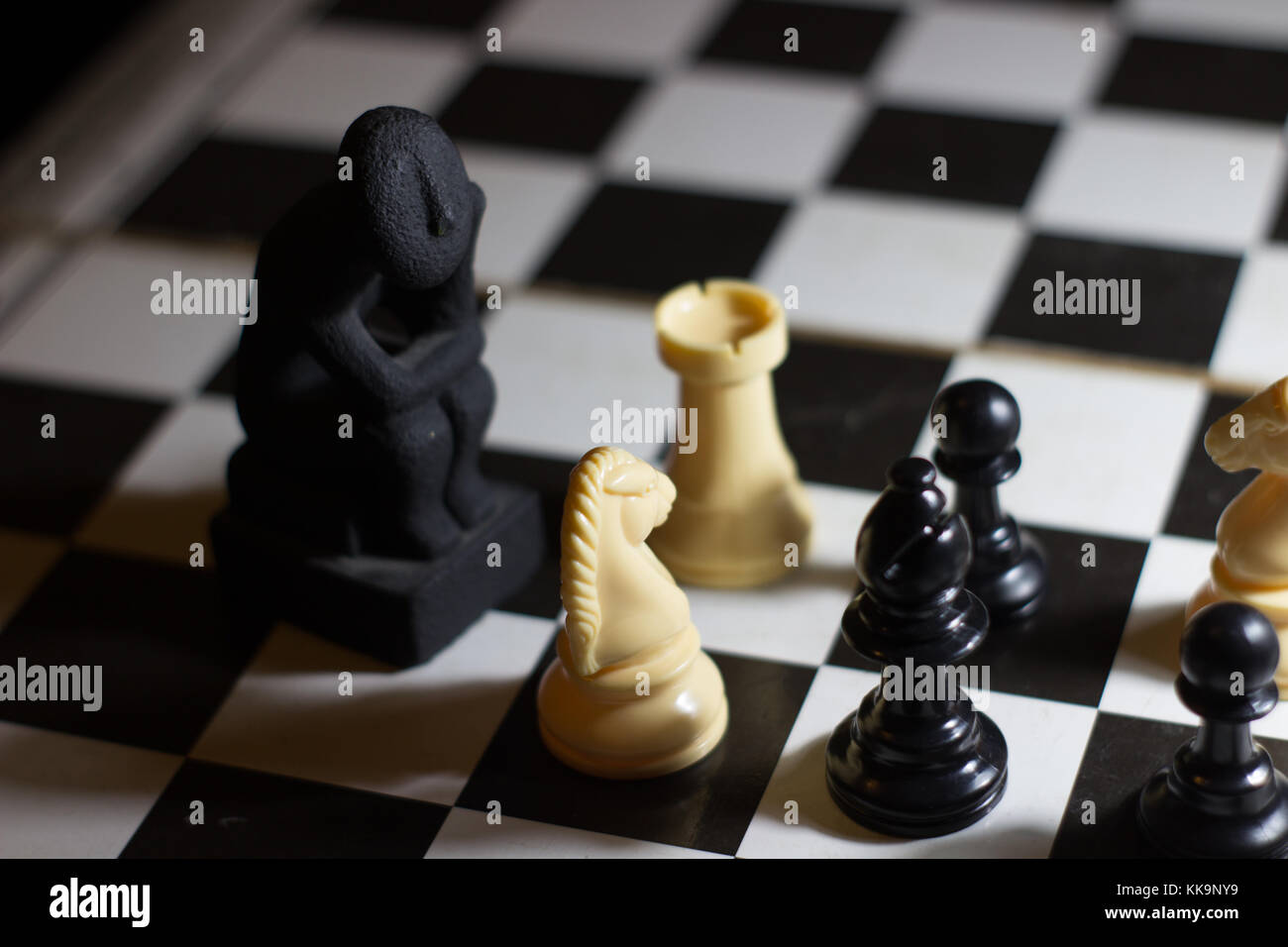 Der Denker Statue auf einem Schachbrett Spule kleine Denken über Strategie Lösung Stockfoto