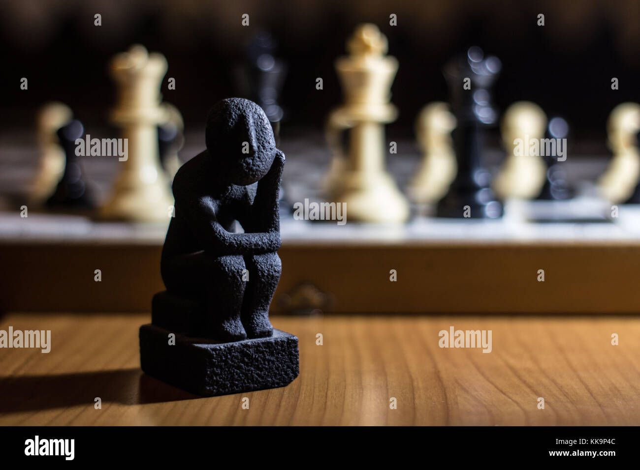 Der Denker Statue auf einem Schachbrett Spule kleine Denken über Strategie Lösung Stockfoto