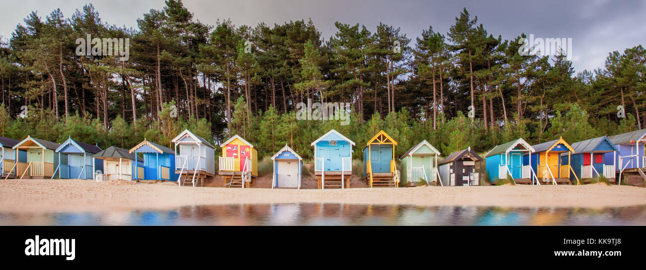 Erhöhte Strandhütten in Norfolk sind einige der Farbenprächtigsten in England, auf dem sandigen nördlichen Norfolk Küste. Sonnenaufgang Wolken mit einem frühen Morn Stockfoto